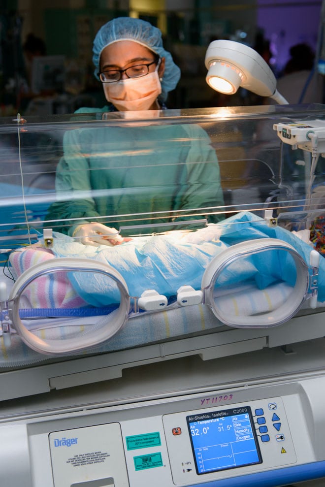 Nurse cares for premature baby in a humidicrib