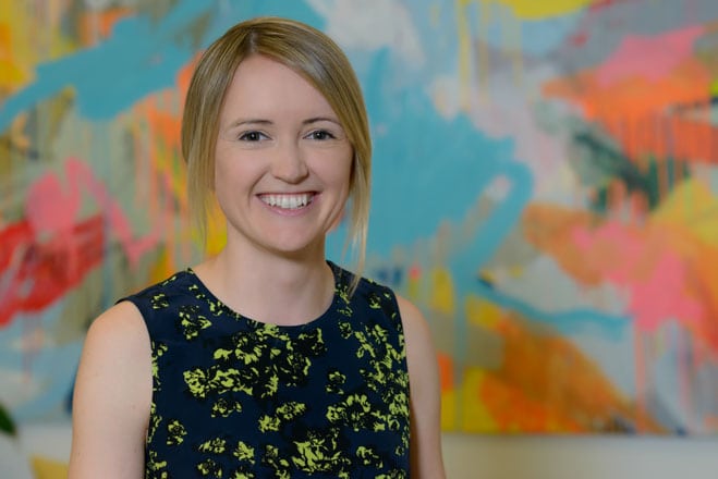 Contemporary corporate headshot of professional woman in front of artwork