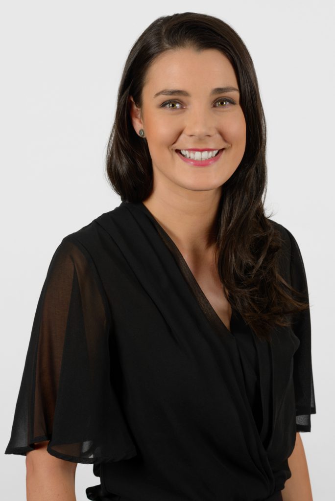 Corporate headshot of a smiling professional female on a plain white background